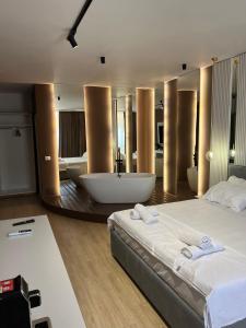 - une chambre avec un grand lit et une baignoire dans l'établissement Capital Suites Center, à Tirana