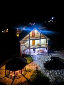 ein kleines Haus mit beleuchtetem Dach in der Nacht in der Unterkunft Guesthouse Besimi in Valbonë