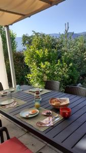 una mesa de madera con platos de comida. en Les Terrasses du Paradis en Orpierre