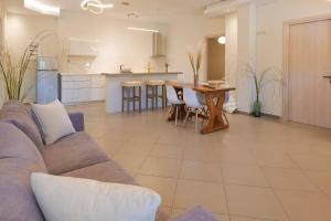 ein Wohnzimmer und eine Küche mit Sofa und Tisch in der Unterkunft Mirabilia deluxe apartment in Arillas