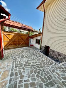 un patio de piedra con una puerta de madera y un edificio en Къща за гости “Александър” en Velingrad