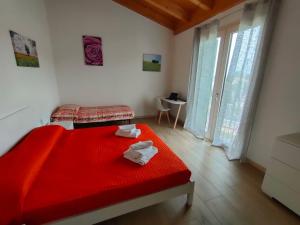 a bedroom with a red bed with a red blanket at Corte del Sole in Valeggio sul Mincio