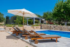 a group of chairs and an umbrella next to a pool at Holiday House Tone, Imotski-Drum-Makarska in Drum