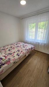 バニャ・ルカにあるVilla Park Banja Lukaのベッドルーム1室(花柄の掛け布団、窓付)
