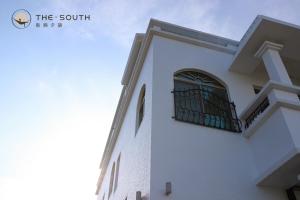 a building with a gate on the side of it at The South-Dawn in Hengchun