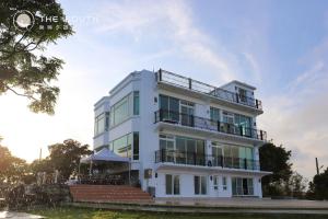 a white building with a balcony on top of it at The South-Dawn in Hengchun