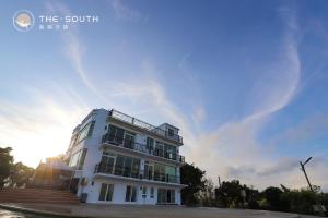 a white building with the sun in the sky at The South-Dawn in Hengchun