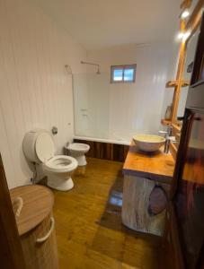 a bathroom with two toilets and a wooden floor at Cabaña Los acantilados in Mar del Plata
