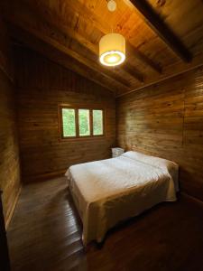 1 dormitorio con 1 cama en una cabaña de madera en Cabaña Los acantilados en Mar del Plata