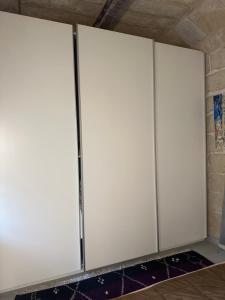 a row of white doors in a room at Luxury room in Gharghur in Għargħur