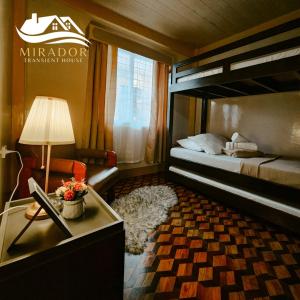 a bedroom with a bunk bed and a table with a lamp at Mirador Old-Time House walking distance to Lourdes Grotto in Baguio
