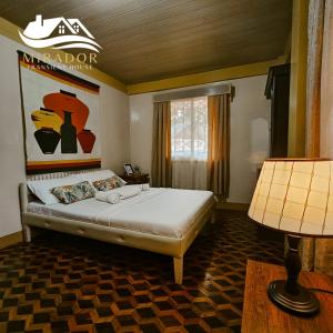 ein Schlafzimmer mit einem Bett und einer Lampe in der Unterkunft Mirador Old-Time House walking distance to Lourdes Grotto in Baguio City