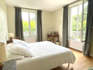 a bedroom with a large white bed with windows at Entre les branches in Saint-Règle