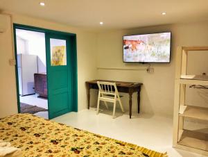 a bedroom with a bed and a desk and a television at Bahama Breeze Beach Apartment in Cap Malheureux