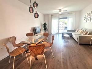 een woonkamer met een glazen tafel en stoelen bij Playa & Golf Deluxe en Playa Granada in Motril