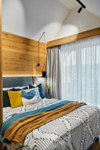 a bedroom with a large bed and a window at TATRA NEST - Apartamenty z Jacuzzi i SPA in Biały Dunajec