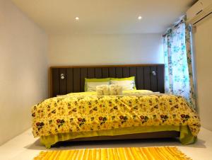 a bedroom with a large bed with a yellow blanket at Bahama Breeze Beach Apartment in Cap Malheureux