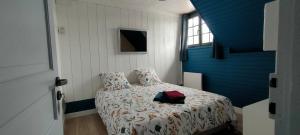 Un dormitorio con una cama con una bolsa roja. en Aux Passagers de la Baie en Le Crotoy