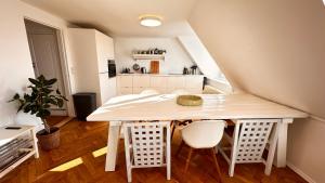 una mesa blanca y sillas en una pequeña cocina en Carolinas Apartment - Studie 4th floor, en Copenhague