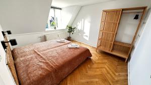 1 dormitorio con 1 cama y suelo de madera en Carolinas Apartment - Studie 4th floor, en Copenhague