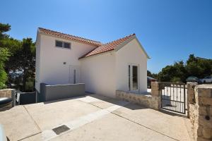 uma casa branca com um portão e uma entrada em Magda em Kožino