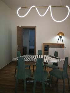 een eetkamer met een tafel en groene stoelen bij DonaLisa in Andrano