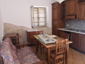 Graticciare的住宿－Porzione di Casale Ultima Spiaggia，厨房配有桌椅和沙发。