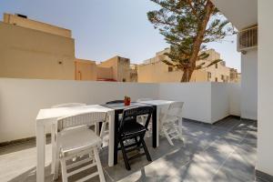 a table and chairs on a balcony with a tree at Central Sliema 3-Bedroom Retreat in Sliema