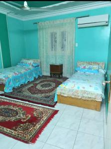 two beds in a room with blue walls at Family friendly 3 bedrooms apartment for rent in Hadayek El Maadi. in Cairo