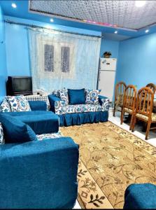 a blue living room with couches and a tv at Family friendly 3 bedrooms apartment for rent in Hadayek El Maadi. in Cairo
