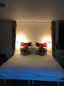 a bedroom with a large bed with red pillows at Fantastic Cotswolds hideaway Cleeve Hill in Southam