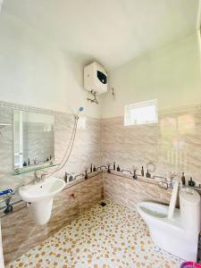 a bathroom with a sink and a toilet and a mirror at Thai Culture Homestay in Mù Cang Chải