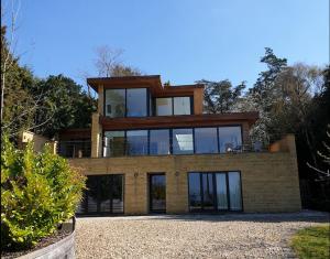 a large house with glass windows on top of it at Fantastic Cotswolds hideaway Cleeve Hill in Southam