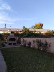 una casa con chimenea de piedra en un patio en Kuća za odmor KOD MARE en Vukovar