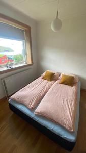 łóżko w sypialni z oknem w obiekcie Cosy house near airport w mieście Sørvágur