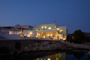 a large white house at night with its lights on at Azura Aqua Foinikas in Finikas