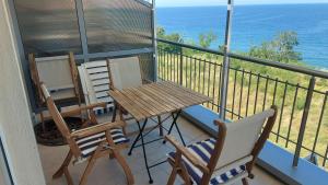Un balcón con 2 sillas y una mesa y sillas de madera. en Sunny House, en Byala