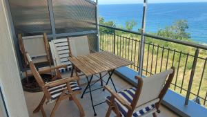 a balcony with two chairs and a wooden table and chairs at Sunny House in Byala