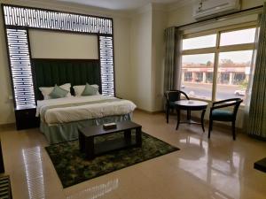 a bedroom with a large bed and a table and chairs at الزمردة للشقق المخدومة in Ash Shuqayq