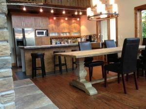a kitchen with a large wooden table and chairs at Chalet Spa Alizee Mont-Blanc in Saint-Faustin