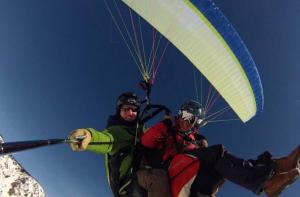 two people are riding a paragliding parachute at The Bagain in Shimla