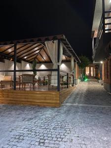 a building with a deck with tables and chairs at night at Hotel Villa Niko Mari in Tbilisi City