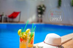 a person sitting next to a pool with a drink at Old Town Point Hotel & Spa Antalya in Antalya