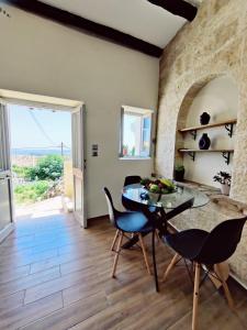 a dining room with a glass table and chairs at Corfu sea view house - Live in Corfu like a local! in Ágios Márkos