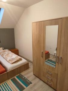 a bedroom with a bed and a cabinet with a mirror at Kuća za odmor KOD MARE in Vukovar