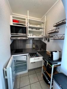 eine kleine Küche mit weißen Schränken und einer Spüle in der Unterkunft Wohnung für 4 Pers in Sechtem bei Köln/Bonn, DB-Anschluß in Bornheim