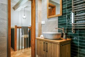 a bathroom with a bowl sink on a wooden cabinet at Apartamenty Krokus przy Polanie Biały Potok in Witów