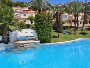 ein großer Pool mit einem Resort im Hintergrund in der Unterkunft Casa Blanca in Alicante