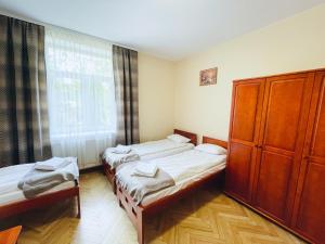 a room with two beds and a window at Parkowa Rezydencja Hubal in Rabka-Zdrój