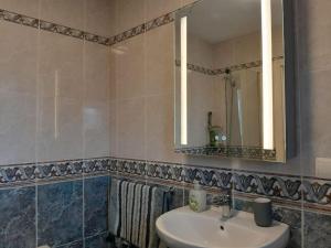 La salle de bains est pourvue d'un lavabo, d'un miroir et de serviettes. dans l'établissement The Beach Hut with Lazy spa, à Adra